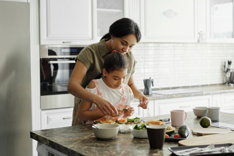 Mulher e filha na cozinha preparando comida