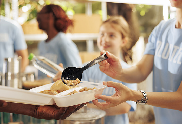 Estudantes servindo refeições escolares.