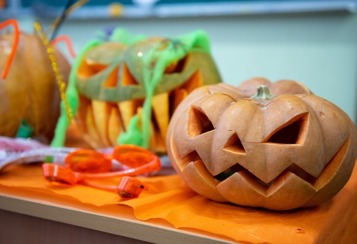 Abóboras esculpidas para decoração de Halloween em escola, promovendo celebração saudável e criativa.
