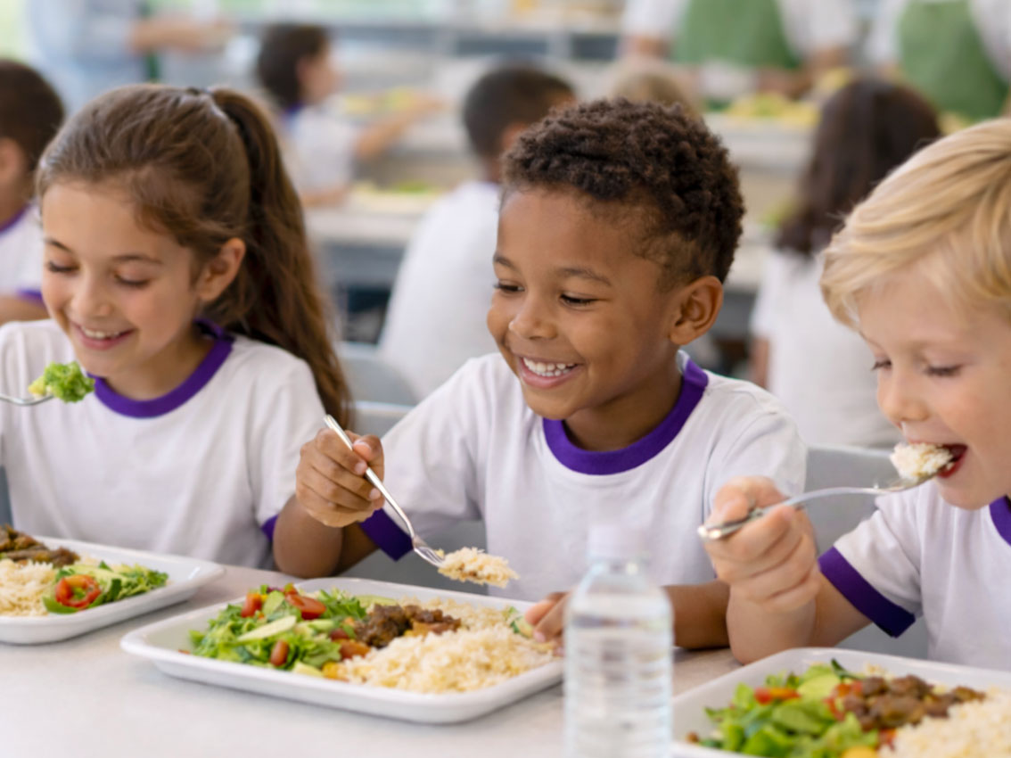 refeitório escolar com crianças se alimentando de forma tranquila